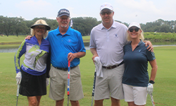 two male and two female golfers posing for a photo